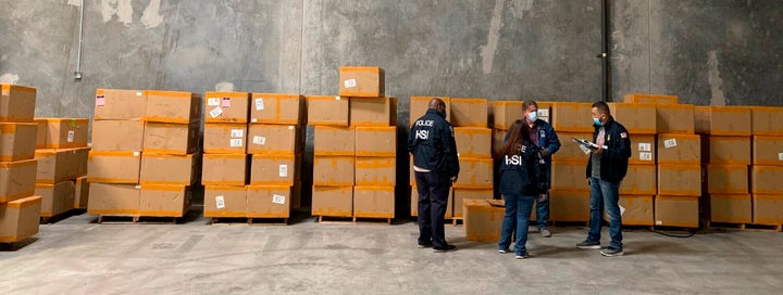 This December 2020, image provided by U.S. Immigration and Customs Enforcement (ICE) shows Homeland Security Investigations El Paso members and U.S. Customs and Border Protection officers working during a seizure of counterfeit N95 surgical masks at an El Paso Port cargo facility in El Paso, Texas. 