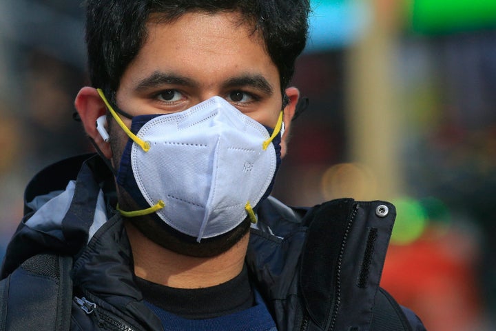 A man wears two face masks in New York City on Dec. 10, 2020. The CDC says people can wear a cloth mask on top of a disposable surgical mask “for better fit and extra protection.”