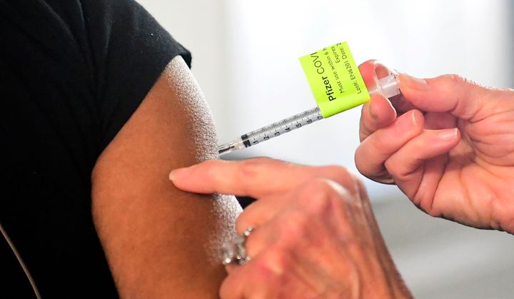 A dose of the Pfizer Covid-19 vaccine is administered on the opening day of a large-scale Covid-19 vaccination site in Pomona