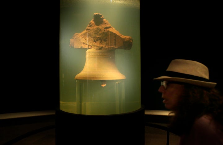 Dans cette photo d'archive datant de 2016, un visiteur du musée passe devant une affiche présentant une cloche qui a appartenu au bateau pirate Whydah Gally, au Whydah Pirate Museum, à Yarmouth, au Massachusetts.