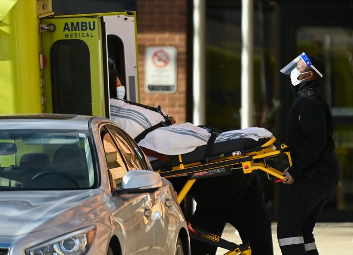 Paramedics take away a person from Revera Westside Long Term Care Home in Toronto during an outbreak of COVID-19 on Dec. 7, 2020.