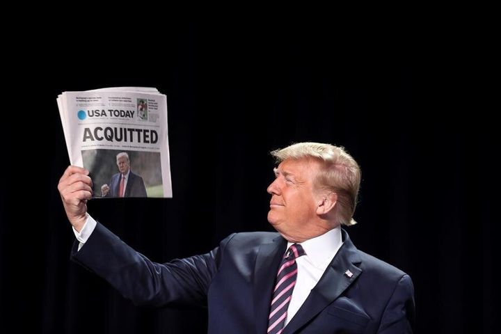 Donald Trump sujeta un periódico tras librarse del primer impeachment, en febrero de 2020.