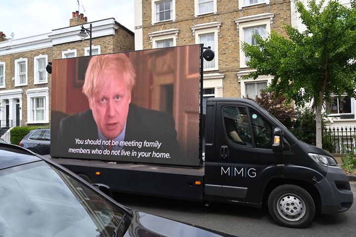 A big screen organised by British political campaign group Led By Donkeys mounted on a vehicle plays a clip from Britain's Prime Minister Boris Johnson's March 23 address to the nation where he explained the stay-at-home coronavirus lockdown rules outside the home of Number 10 Downing Street special advisor Dominic Cummings in London on May 24.
