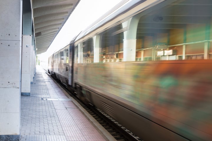 Electric train passing, motion blurred at a train station in Greece.