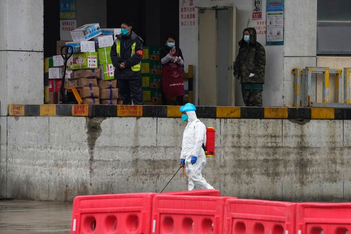 A worker in protective overall passes by a warehouse at the Baishazhou wholesale market during a visit by the World Health Organisation on the third day of field visit in Wuhan in central China's Hubei province last month.