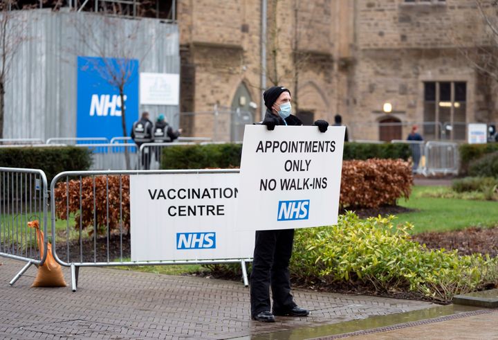A security guard holds a sign at Blackburn Cathedral, which is being used as a mass vaccination center during the coronavirus outbreak in Blackburn. 