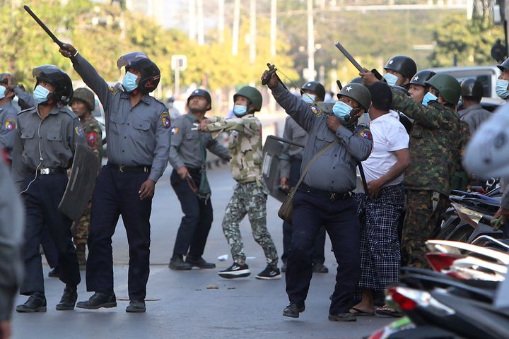 A policeman aims a slingshot towards an unknown target during a crackdown on anti-coup protesters holding a rally in front of the Myanmar Economic Bank in Mandalay, Myanmar, on Feb. 15, 2021. 