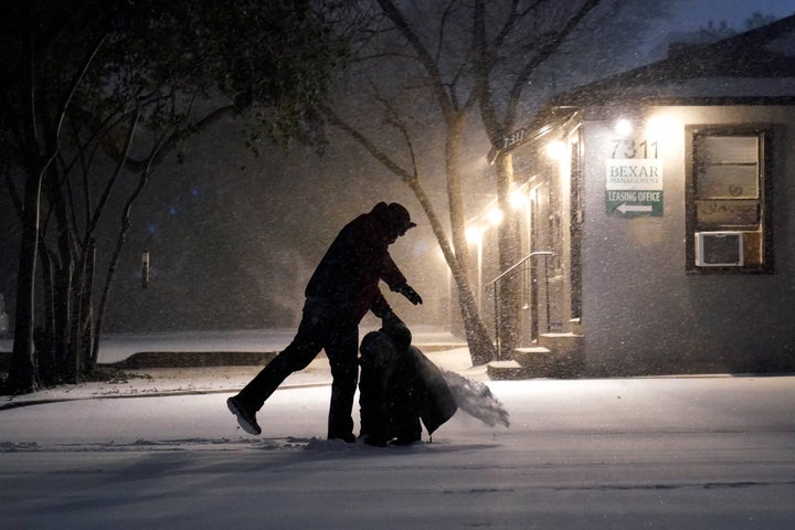 Two people play in the snow in San Antonio, Sunday, Feb. 14, 2021. (AP Photo/Eric Gay)