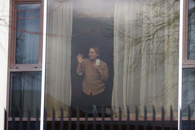 Zari Tadayon gestures from a window of the Radisson Blu Hotel.