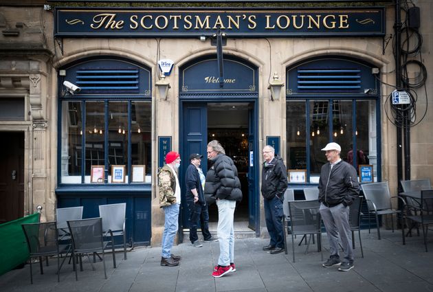 People wait for opening outside The Scotsman's Lounge pub in Edinburgh 