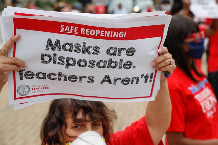 A woman holds a sign during the Occupy City Hall Protest and Car Caravan hosted by Chicago Teachers Union in Chicago, Illinois, on Aug. 3, 2020.