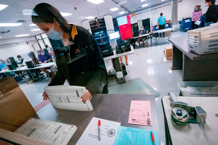 A poll worker sorts ballots inside the Maricopa County Election Department in Phoenix on Nov. 5, 2020.