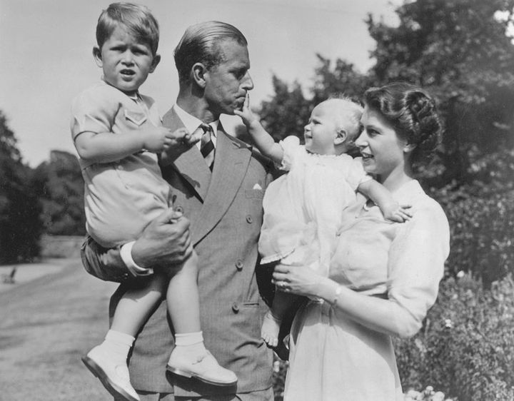 The duke being playful with Anne, while holding Charles, in the grounds of Clarence House in 1951
