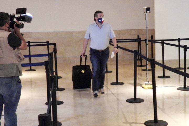 Sen. Ted Cruz checks in for his flight at Cancun International Airport on Thursday.