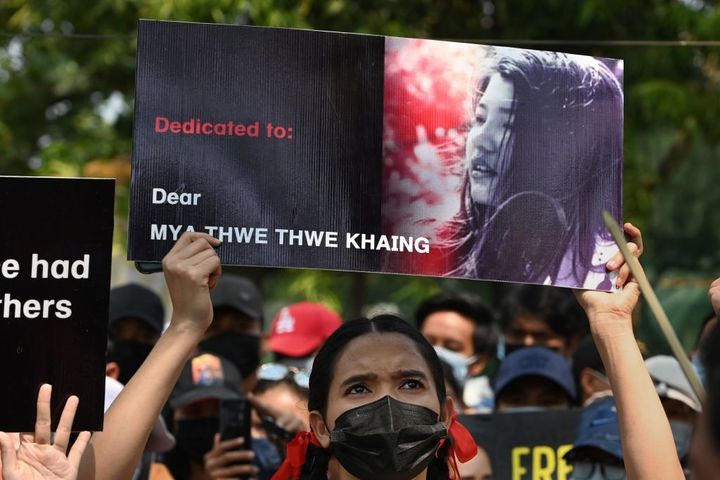 A protester holds up a poster with a portrait of Mya Thwate Thwate Khaing who died from a gunshot wound after being shot in the head last week, during a demonstration against the military coup in Yangon on Feb. 19, 2021. 