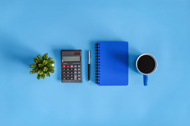 Coffee Break. Calculator and Notebook on Blue Desk