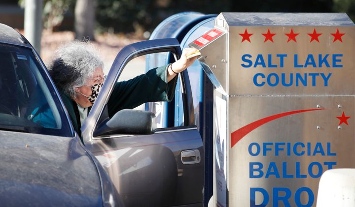 A voter drops off her mail in ballot at a dropbox at the Salt Lake County election office in Salt Lake City, Utah, on Oct. 29, 2020.