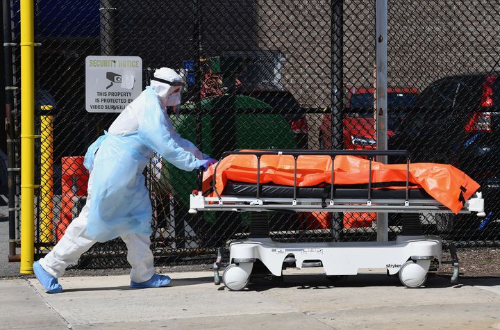 A staff member at the Wyckoff Heights Medical Center in New York moves a body to a refrigerated truck on April 2, 2020, as coronavirus cases ravaged the city and state.