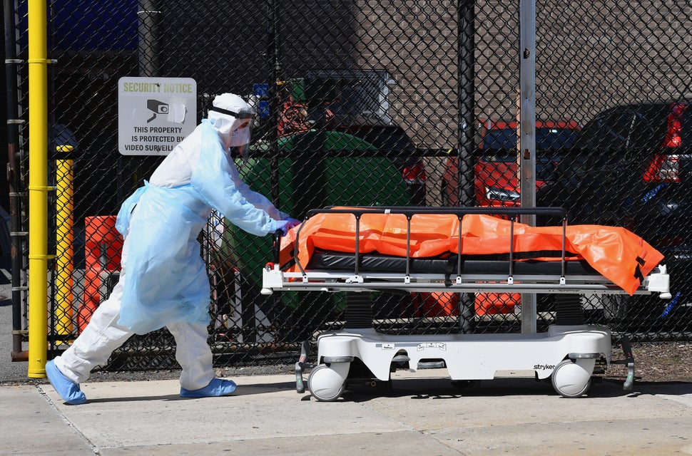A staff member at the Wyckoff Heights Medical Center in New York moves a body to a refrigerated truck on April 2, 2020,