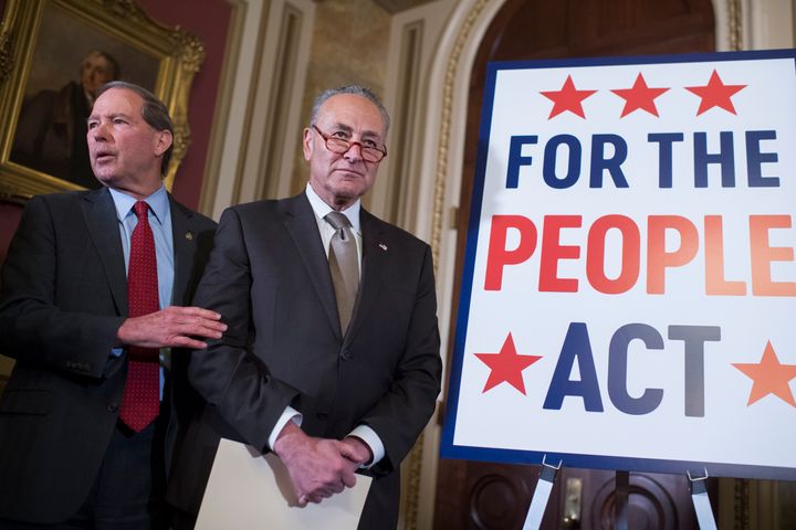 Then-Senate Minority Leader Charles Schumer (center) and then-Sen. Tom Udall (D-N.M.) attend a news conference about the For the People Act on March 27, 2019, in the U.S. Capitol.