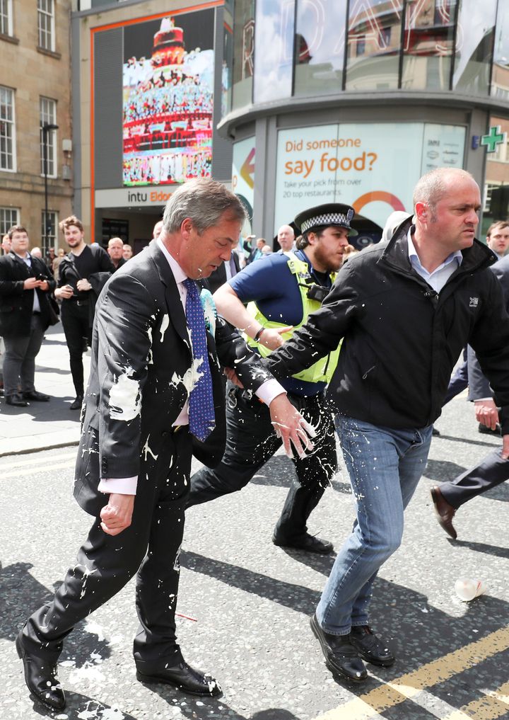 Brexit Party leader Nigel Farage gestures after being hit with a milkshake while arriving for a Brexit Party campaign event in Newcastle.