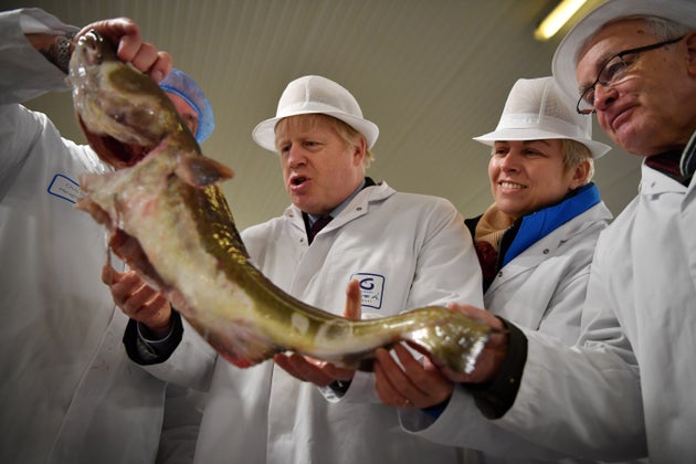 Boris Johnson holds a fish during a general election campaign visit to Grimsby Fish