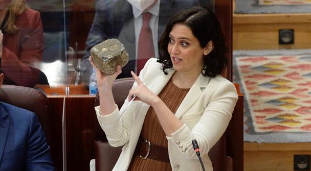 Isabel Díaz Ayuso sostiene un adoquín.