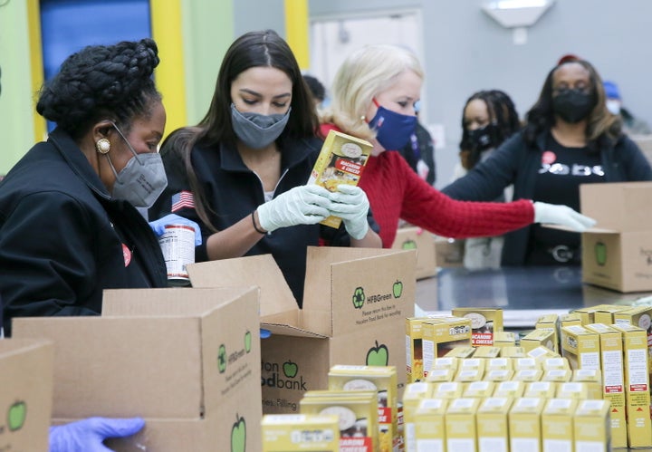 U.S. Rep. Sheila Jackson Lee (D-Texas), Rep. Alexandria Ocasio-Cortez (D-N.Y.) and Rep. Sylvia Garcia (D-Texas) load boxes at their work station at the Houston Food Bank in Houston, Texas, on Feb. 20, 2021.