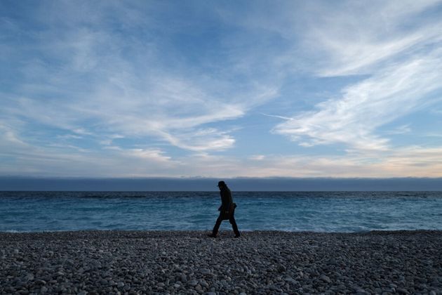 Un homme marche sur une plage de Nice le 16 février 2021