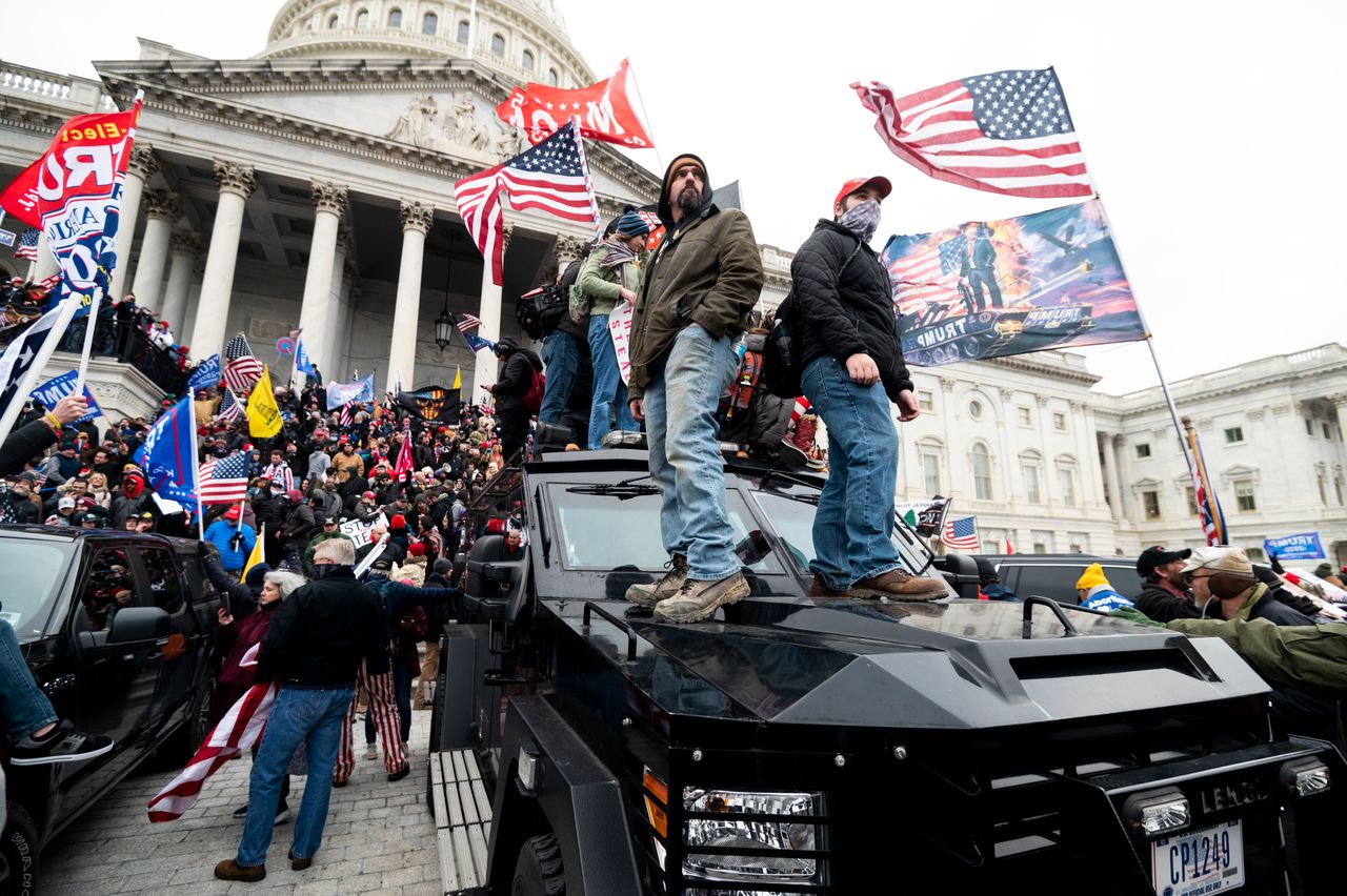 Trump supporters stand on U.S. Capitol Police armored vehicles as others take over the steps of the Capitol on Jan. 6, 2021.