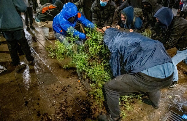 Un grupo de manifestantes mueve una jardinera para montar una barricada durante las protestas por el...