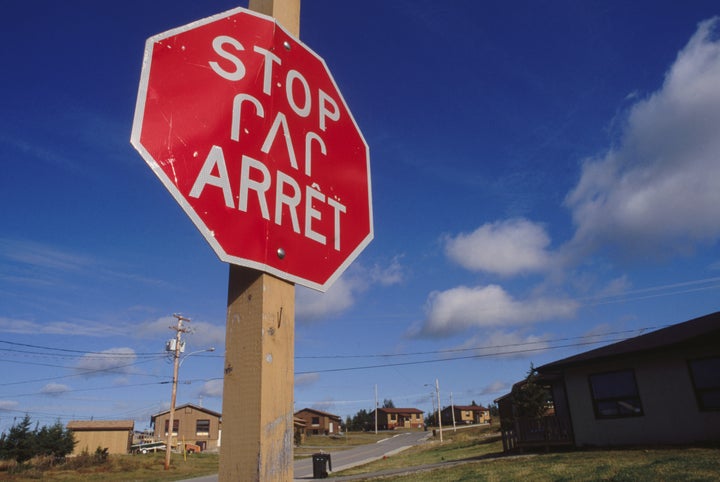 A stop sign in English, French and Cree languages.