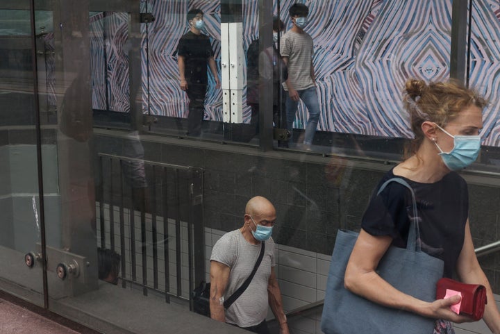 Commuters wearing protective face masks in accordance with new public health regulations for riding public transit depart a train station in the wake of a coronavirus disease (COVID-19) outbreak in Sydney, Australia.