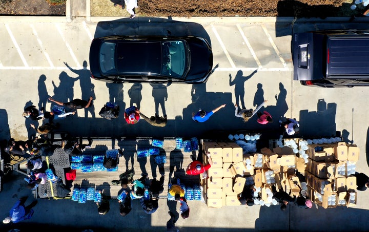 Volunteers direct traffic as they pass out water during a water distribution event at the Fountain Life Center on Feb. 20 in Houston, Texas.