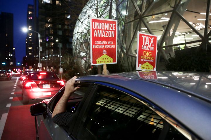 A sign supporting Amazon workers unionizing in Bessemer, Alabama, is pictured on a car during a Tax Amazon Car Caravan and Bike Brigade around the Amazon Spheres to defend a payroll-based tax on big businesses, including Amazon, that passed last July in Seattle, Washington, on Feb. 20.