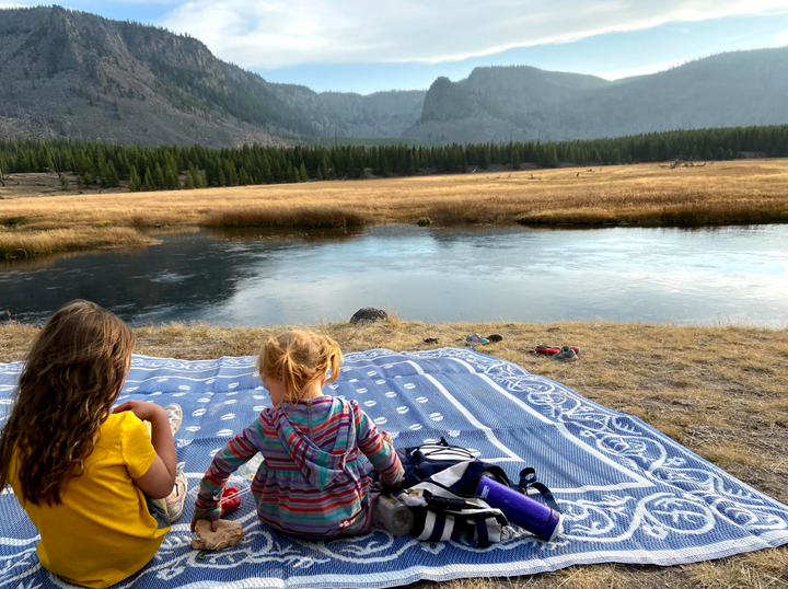 The author's daughters enjoying a picnic along the Firehole River in Yellowstone National Park in October 2020.