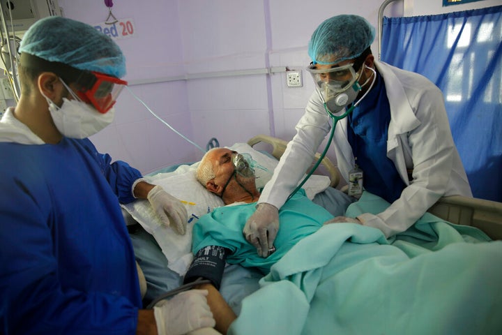 Medical workers attend to a COVID-19 patient in an intensive care unit at a hospital in Sanaa, Yemen, on June 14, 2020.