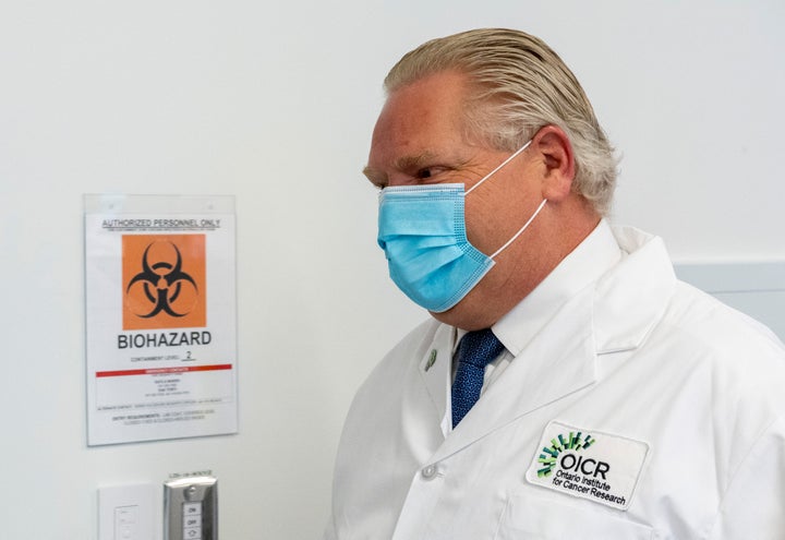 Ontario Premier Doug Ford tours a lab at the Ontario Institute for Cancer Research in Toronto on Feb. 23, 2021.