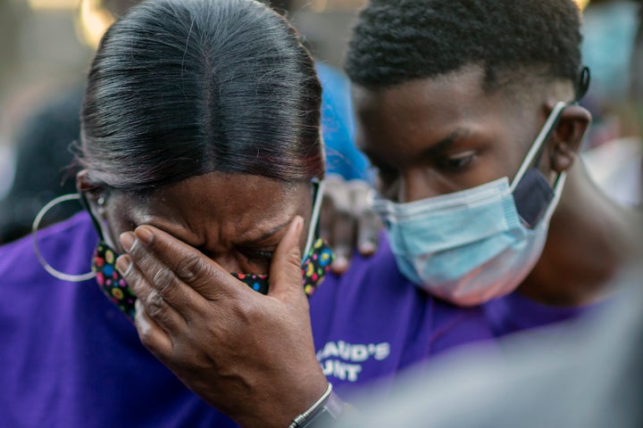 Evon Arbery, Ahmaud Arbery's aunt, is comforted by a family member during Tuesday's memorial walk and candlelight vigil.