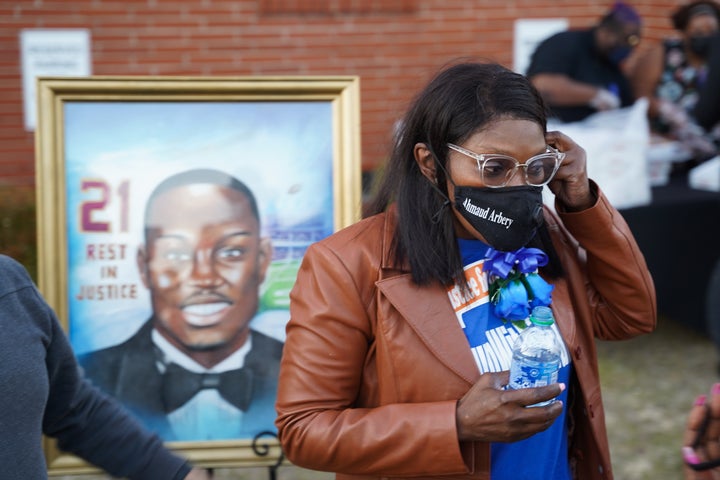 Wanda Cooper-Jones, the mother of Ahmaud Arbery, stands in front of a painting of her son after a candlelight vigil for him on Tuesday at the New Springfield Baptist Church in Waynesboro, Georgia. Arbery was shot and killed while jogging near Brunswick, Georgia, a year ago on Tuesday after being chased by two white men.