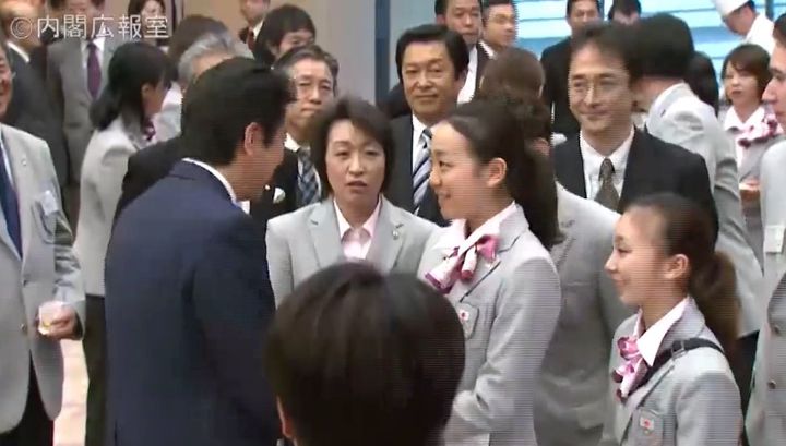 橋本聖子氏（中央）が浅田真央選手に安倍首相とのハグを勧めるシーン（政府インターネットテレビより）