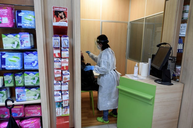 Una farmacéutica realiza una prueba de antígenos en una farmacia de