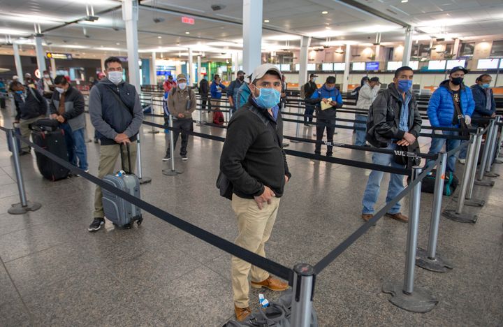 Migrant workers from Mexico maintain social distancing as they wait to be transported to Quebec farms after arriving at Trudeau Airport Tuesday April 14, 2020 in Montreal.