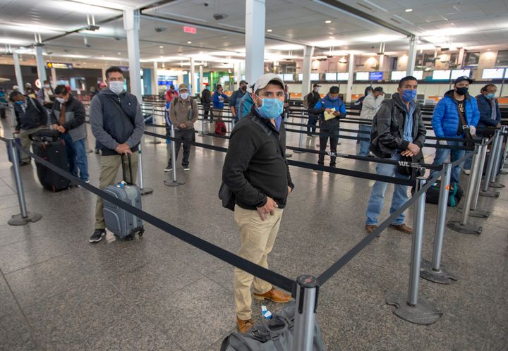 Des travailleurs mexicains maintiennent la distanciation à leur arrivée à l'aéroport Trudeau avant d'être conduits vers les fermes du Québec, le mardi 14 avril 2020.