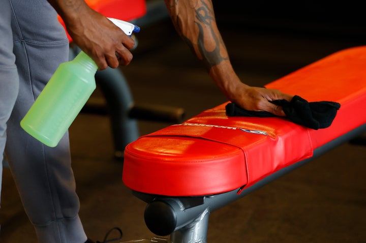 Army Vet Valentino Murray cleans a bench before using it at the Workout Anytime Powder Springs Gym on April 24, 2020 in Powder S