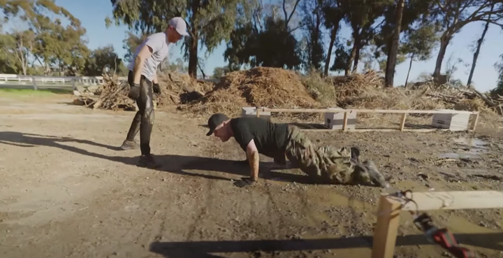 James Corden hams up his repulsion during the mud crawl exercise. 