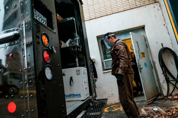 A UPS employee looks at the box containing some of the first Covid-19 vaccines before delivering it to a geriatric centre in Montreal, on Dec. 14, 2020.