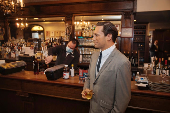 A wax statue of actor John Hamm stands by the bar with a drink at Peter Luger Steakhouse on Friday, Feb, 26, 2021, in New York. The statue, on loan from Madame Tussauds, will help fill out the restaurant during COVID-19 occupancy restrictions.