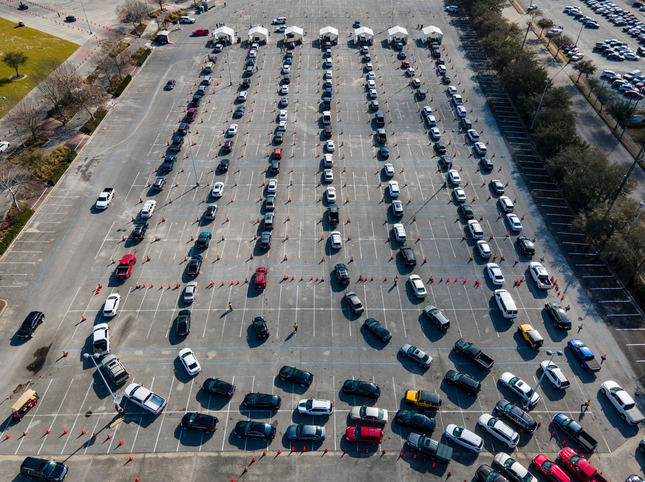 Cars line up in a parking lot at NRG Park in Houston as people wait to receive a COVID-19 vaccines at the federally supported supersite Thursday.