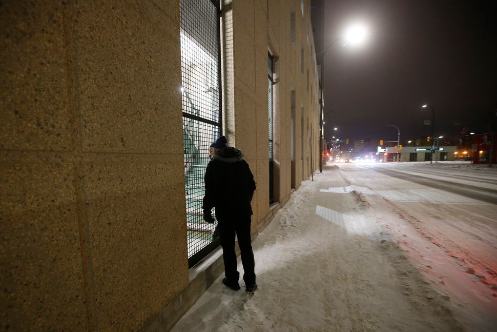 Peter Oyeniyi, van outreach worker with the Salvation Army Extreme Environment Response Vehicle checks a Winnipeg parkade staircase where the homeless stay in the early hours of Saturday morning on Feb. 2, 2019.